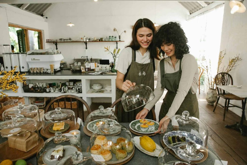 Beyond Recycling: Innovative Ways Restaurants Can Embrace Sustainability Happy women serving desserts in cafe