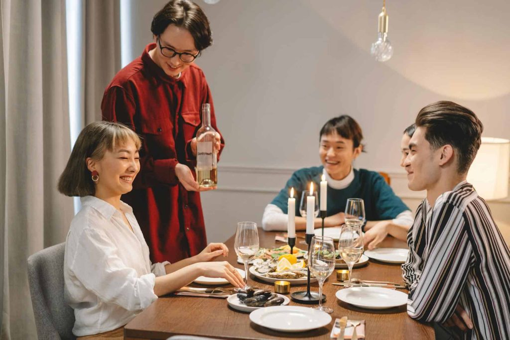 Hosting a Dinner Party? Here's How to Make it Unforgettable! friends having an unforgettable dinner party at home