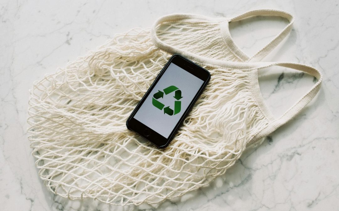 Mobile phone with green recycling sign and mesh bag