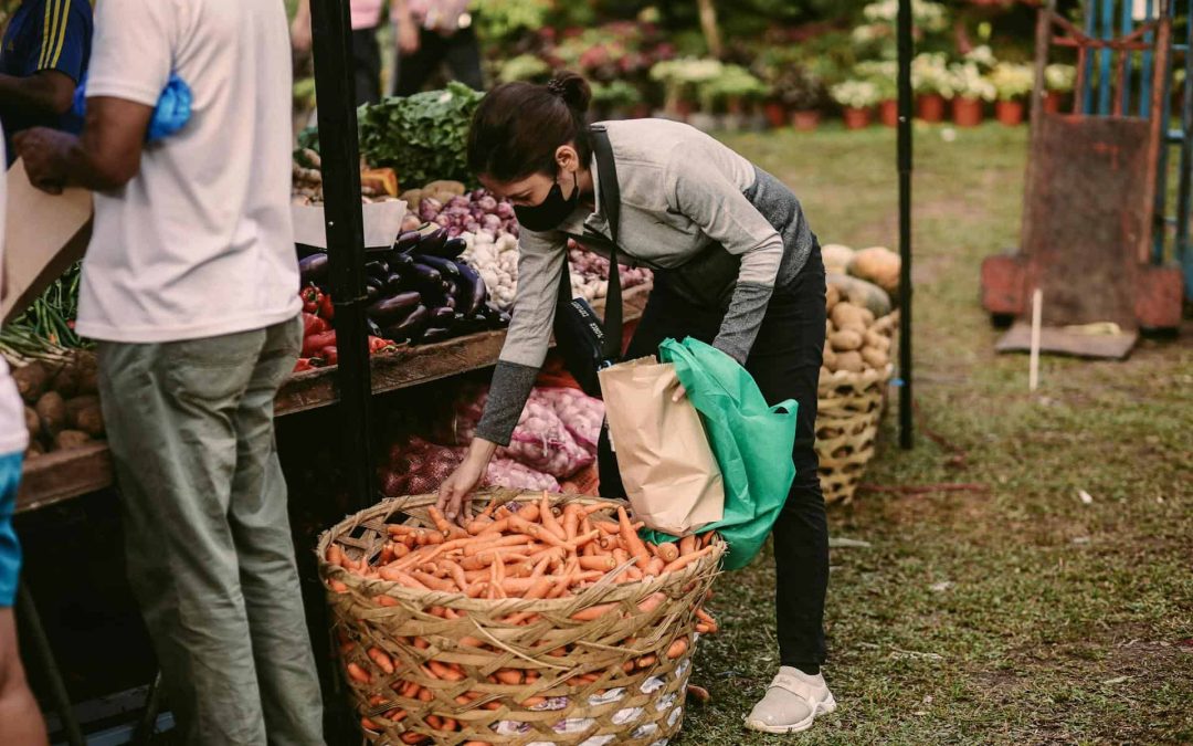 Female Vendor picking Carrots from a Wicker Basket